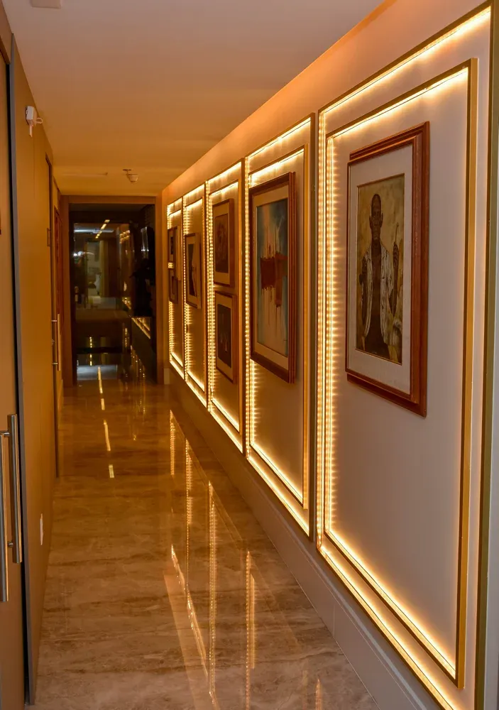 Corredor-galeria com quadros e iluminação em LED