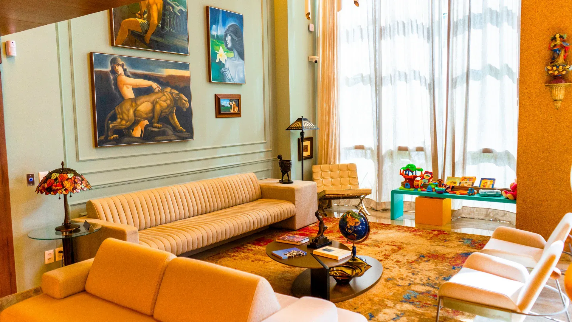 Lounge com sofás creme, tapete persa e obras de arte