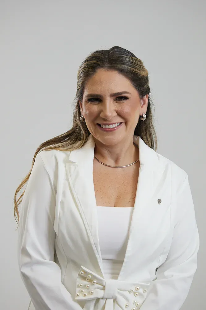 Dra. Nathália da Escóssia sorrindo, de jaleco branco