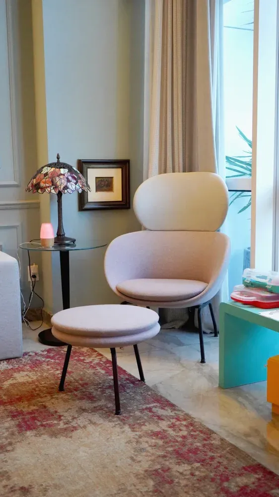 Sala de conforto com poltrona rosa e luminária Tiffany